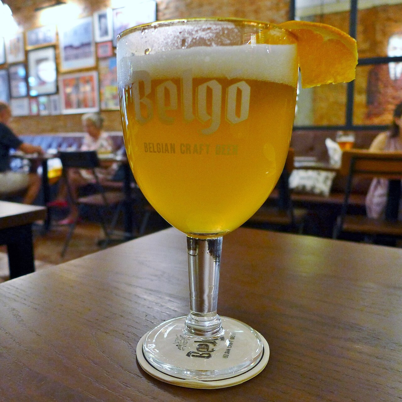 Belgo Wit beer photographed at Belgo Tôn Thất Thiệp in 2023, with the bar interior behind it