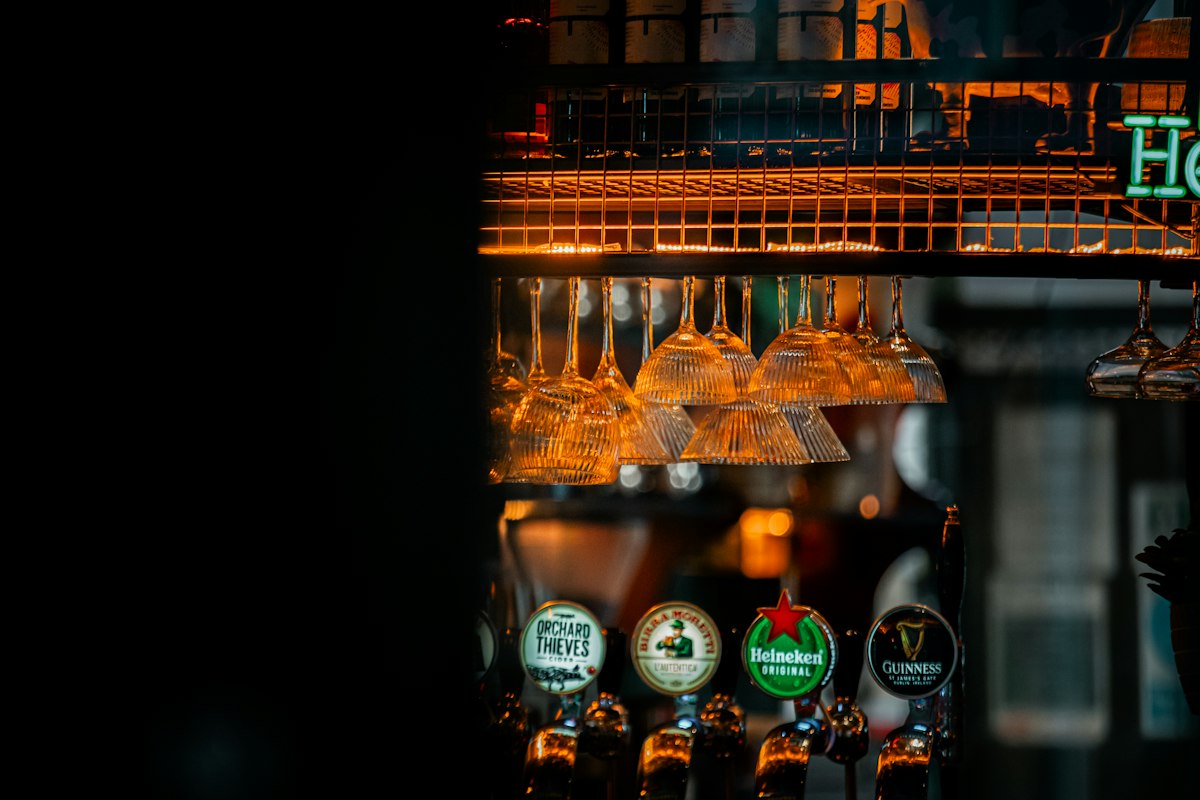 Beer taps under the lights of a dim bar (illustrative photo)