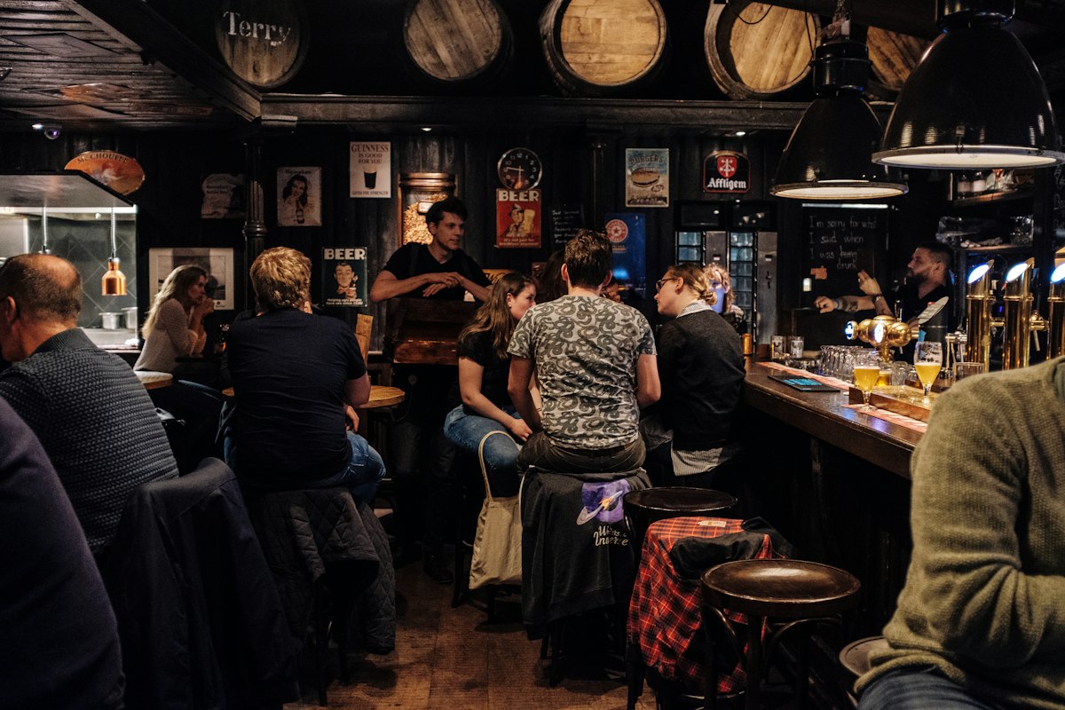 People talking over drinks at a pub counter (illustrative photo)