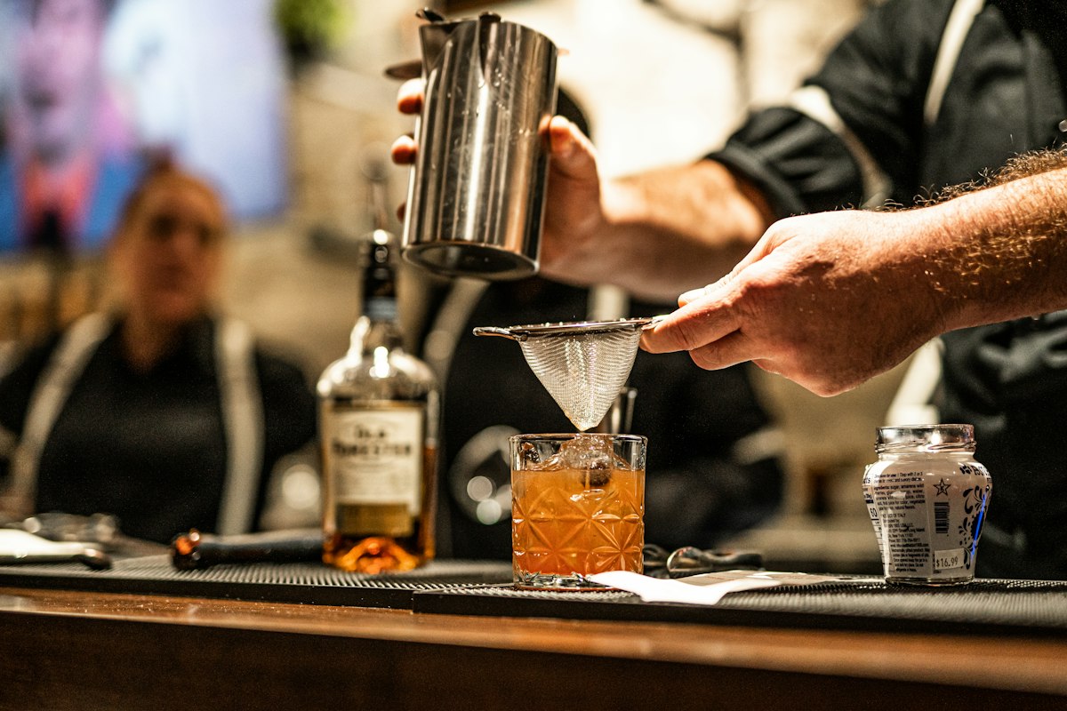 Bartender pouring whisky into a glass (illustrative photo)